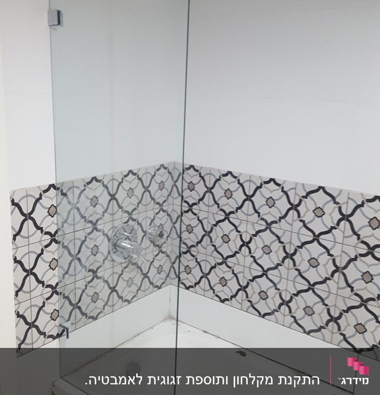 אמבטיה עם מחיצה זכוכית ודוגמת אריחים גיאומטרית